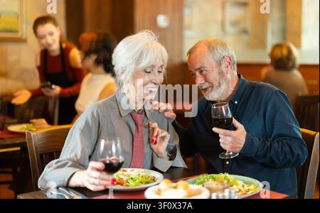 Couple de personnes âgées mangeant et parlant au restaurant Banque D'Images