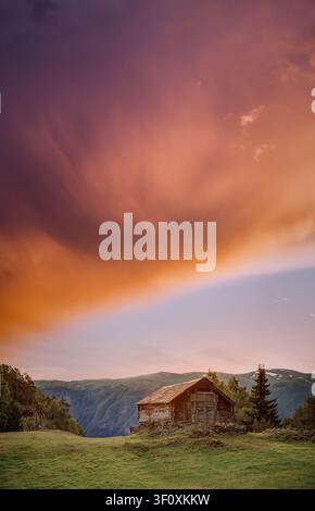 Ancienne cabane en bois surplombant le fjord d'Aurland au coucher du soleil en Norvège. Banque D'Images
