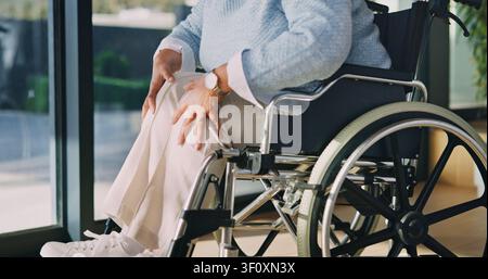Sénior, femme et douleur au genou avec fauteuil roulant à la maison pour blessure à la jambe, inflammation des articulations ou récupération. Personne âgée, patiente ou femme avec un Banque D'Images