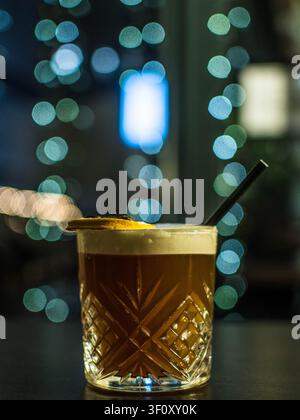 Cocktail Old Fashioned garni d'une tranche d'orange dans un verre à whisky en cristal Banque D'Images