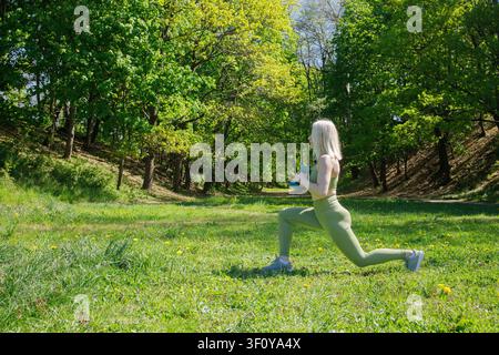 Belle femme blonde sportive faisant des exercices avec des haltères Banque D'Images