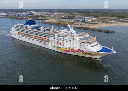 Velsen-Noord, Hollande-Septentrionale, Pays-Bas - 06 juillet 2026 : Vue aérienne d'un navire de la Norwegian Cruise Line naviguant près de la côte, avec un port industriel Banque D'Images