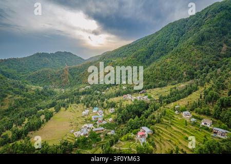 Une vue aérienne capture un petit village entouré de montagnes luxuriantes près du lac Kareri à Dharamshala, en Inde. Banque D'Images