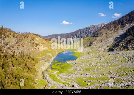 Une vue aérienne du paisible lac Kareri niché entre des pentes rocheuses dans les montagnes à Dharamshala, Himachal Pradesh. Banque D'Images