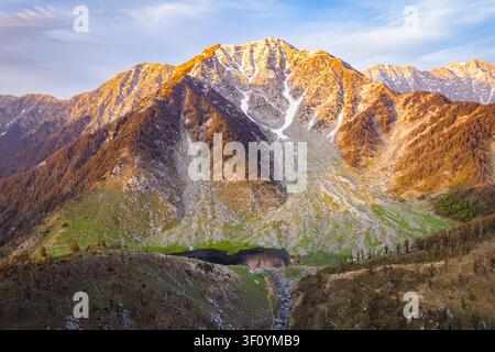Une vue aérienne du paisible lac Kareri entouré de pics montagneux abrupts de l'Himalaya dans l'Himachal Pradesh. Banque D'Images
