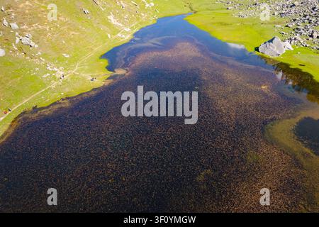 Une vue aérienne du lac paisible de Kareri entouré de prairies verdoyantes dans les montagnes de l'Himachal Pradesh. Banque D'Images