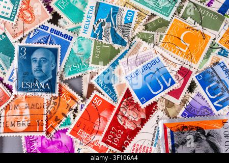 De nombreuses vieilles timbres sont étalées sur une table. La collection comprend des timbres de différents pays et de divers motifs. La lumière brille sur les colorés s Banque D'Images