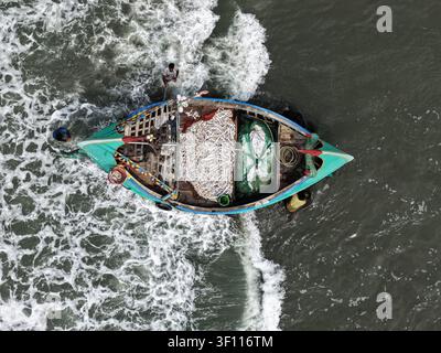 Cox's Bazar, Bangladesh – 10 avril 2026 : Vue aérienne d'un bateau de pêche traditionnel rempli d'une prise fraîche de poisson, avec des pêcheurs travaillant à bord Banque D'Images