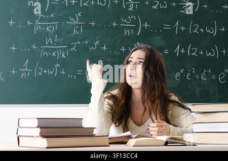 Jeune femme professeur de mathématique à l'avant du tableau Banque D'Images