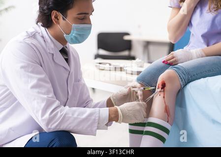 Jeune femme blessés jambe homme médecin visite Banque D'Images