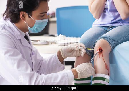 Jeune femme blessés jambe homme médecin visite Banque D'Images