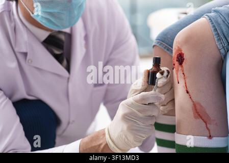 Jeune femme blessés jambe homme médecin visite Banque D'Images