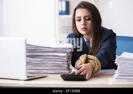Belle jeune employé attaché avec une corde dans le bureau Banque D'Images