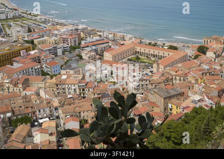 Une perspective aérienne de la ville côtière de Cefalù, en Sicile. L'image capture l'architecture dense et historique aux toits rouges et la mer, montrant la b Banque D'Images