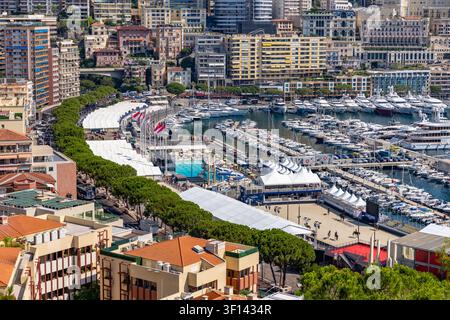Vue du port Hercule à Monaco-Ville avec des yachts de luxe, des tentes d'événement blanches et l'architecture urbaine environnante, Monaco-Ville, Monaco. Banque D'Images