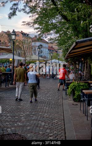 Les visiteurs se promènent parmi les terrasses de restaurants animées au bord de la rivière dans la vieille ville de Ljubljana, en Slovénie. Banque D'Images
