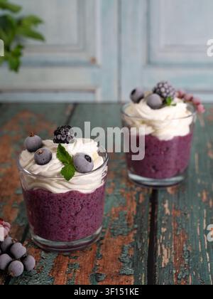Pudding au chia en couches préparé avec un smoothie aux baies, garni de crème fouettée et de baies fraîches Banque D'Images