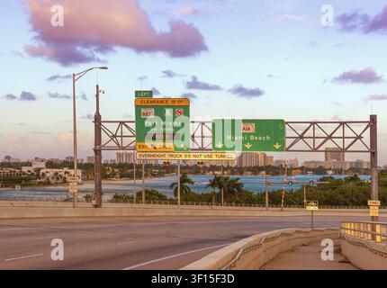 Panneaux de signalisation pour Miami Beach, Floride, États-Unis, au MacArthur Causeway au coucher du soleil Banque D'Images