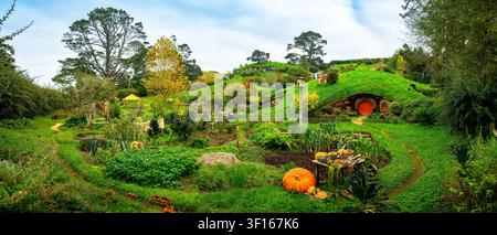 Une vue panoramique étendue du site de tournage verdoyant de Hobbiton à Matamata, en Nouvelle-Zélande, présentant des trous de hobbit charmants et des jardins potagers rustiques Banque D'Images