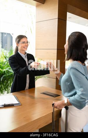 Réceptionniste remettant une carte-clé à une cliente d'hôtel Banque D'Images