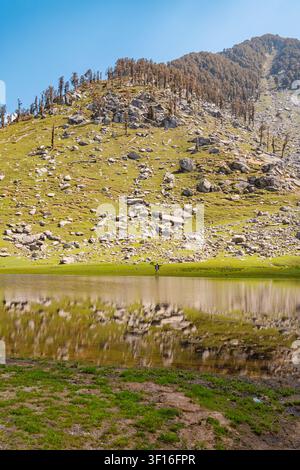 Un paysage tranquille mettant en vedette les eaux miroitantes du lac Kareri nichées contre des pentes montagneuses escarpées. Banque D'Images