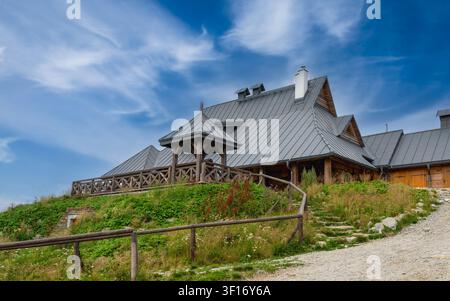 Vue en contre-plongée d'un abri montagneux traditionnel en bois polonais (Chatka Puchatka à Bieszczady) avec un toit en métal gris et une grande terrasse en bois Banque D'Images