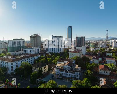 Panorama aérien de la ville de Hué dans le Thua Thien Hué, au Vietnam, montrant des tours modernes, des bâtiments historiques, des toits et des montagnes au loin Banque D'Images