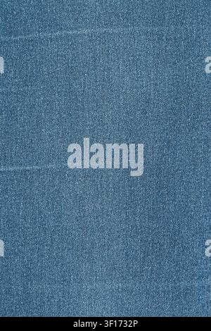Vue rapprochée de dessus sur un textile en denim bleu. Une photographie macro détaillée met en valeur le tissage sergé traditionnel et la texture du tissu. Fond vide et polyvalent f Banque D'Images