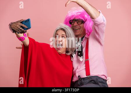 Couple de personnes âgées heureux agissant de manière idiote en prenant un selfie amusant Banque D'Images