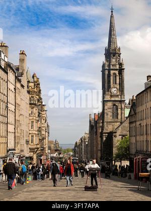 Vue le long de la célèbre Royal Mile d'Édimbourg en direction de Tron Kirk. À l'origine une route processionnelle royale, ses fondations remontent au XIIe siècle. La Royal Mile (Am Mìle Rìoghail) relie le château d'Édimbourg au palais de Holyrood, deux sites du patrimoine royal majeurs dans l'histoire de l'Écosse, et mesure presque exactement une mile de long. Elle monte en pente du nord au sud et comprend l'esplanade du château, Castlehill, le Lawnmarket, la High Street, le Canongate et l'Abbey Strand. C'est de loin la rue touristique la plus fréquentée de la vieille ville. À droite se dresse Tron Kirk. Construite au XVIIe siècle, elle a été utilisée a Banque D'Images
