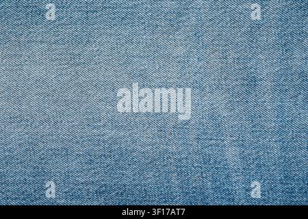 Macro détaillée du tissu denim bleu clair. Fond textile classique en coton présentant un motif twill diagonal. Parfait pour la mode, le design ou l'abstrait Banque D'Images