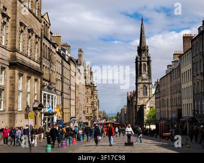 Vue le long de la célèbre Royal Mile d'Édimbourg en direction de Tron Kirk. À l'origine une route processionnelle royale, ses fondations remontent au XIIe siècle. La Royal Mile (Am Mìle Rìoghail) relie le château d'Édimbourg au palais de Holyrood, deux sites du patrimoine royal majeurs dans l'histoire de l'Écosse, et mesure presque exactement une mile de long. Elle monte en pente du nord au sud et comprend l'esplanade du château, Castlehill, le Lawnmarket, la High Street, le Canongate et l'Abbey Strand. C'est de loin la rue touristique la plus fréquentée de la vieille ville. À droite se dresse Tron Kirk. Construite au XVIIe siècle, elle a été utilisée a Banque D'Images