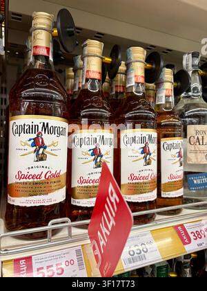 11.07.2026 Ukraine, Kharkov Rangée de bouteilles de rhum Captain Morgan Spiced Gold sur une étagère de supermarché avec étiquettes de prix discount Banque D'Images