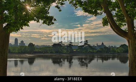 Lac Casa de Campo au coucher du soleil avec des reflets et l'horizon de Madrid en arrière-plan, Espagne. Banque D'Images