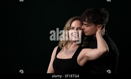 Jeune homme embrassant le cou de la femme, exprimant l'amour et la connexion Banque D'Images