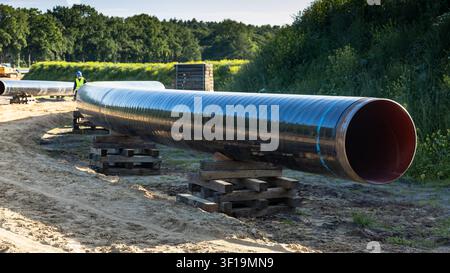Section de pipeline en acier de grand diamètre stockée sur des supports avant l'installation sur un chantier de construction d'infrastructures Banque D'Images