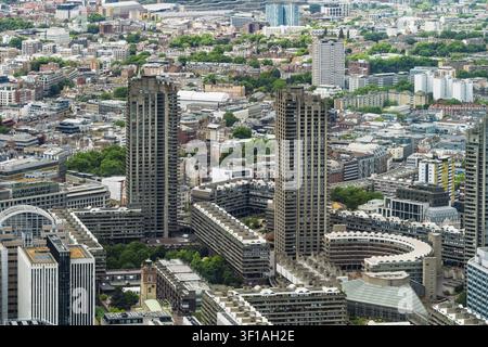 Vue aérienne du Barbican Estate présentant ses tours hautes brutalistes emblématiques, ses blocs résidentiels et les espaces verts environnants à Londres, Angleterre Banque D'Images