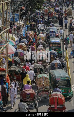 Dhaka, Bangladesh - 27 février 2017 : Une vue en hauteur montre une rue remplie de gens, de cyclorickshaws et d'autorickshaws, créant un trafic dense Banque D'Images