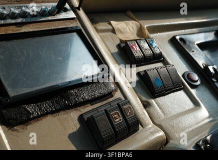 La partie avant d'un siège de conducteur dans un grand bus public. Il possède un écran d'infotainement, des boutons, des cadrans, des interrupteurs et de nombreux autres contrôles fins. Banque D'Images