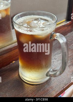 Tonique espresso rafraîchissant servi sur glace dans une tasse en verre transparent, combinant espresso et eau tonique pour une boisson café spécialité. Banque D'Images