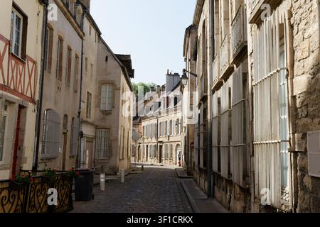 Des bâtiments historiques bordent une rue pavée sinueuse dans la vieille ville de Beaune Banque D'Images