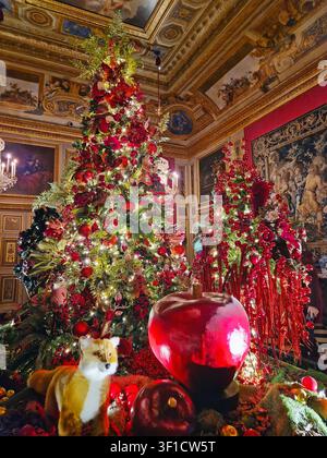Maincy, France – 11 décembre 2025 : arbre de Noël opulent richement décoré dans des tons rouge foncé et or, situé dans un hall élégant doté d’un c peint Banque D'Images