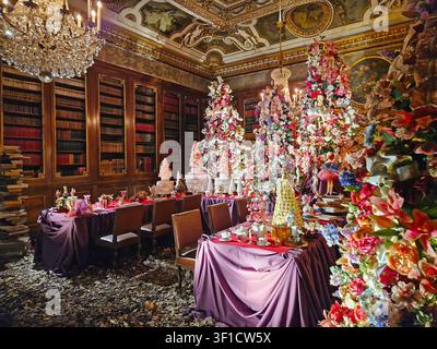 Maincy, France - 11 décembre 2025 : Une salle luxueuse préparée pour un thé de Noël décorée avec des fleurs colorées abondantes, des rubans et des figurines de fées Banque D'Images