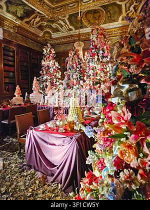 Maincy, France - 11 décembre 2025 : Une salle luxueuse préparée pour un thé de Noël décorée avec des fleurs colorées abondantes, des rubans et des figurines de fées Banque D'Images