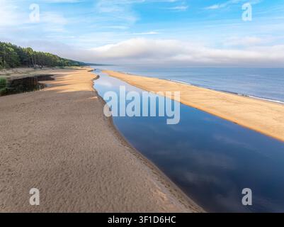 Vue aérienne de l'embouchure de la rivière Peterupe et du littoral de la mer Baltique près de Saulkrasti, Lettonie, au lever du soleil en été Banque D'Images