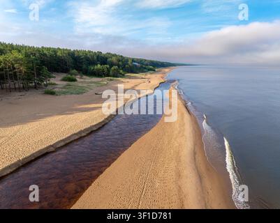 Estuaire de la rivière Peterupe se déversant dans la mer Baltique près de Saulkrasti, Lettonie, au lever du soleil vu depuis les airs Banque D'Images