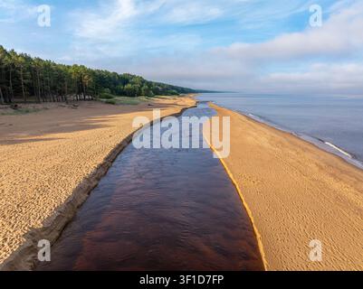 Estuaire de la rivière Peterupe et côte de la mer Baltique près de Saulkrasti, Lettonie, capturé par drone au lever du soleil Banque D'Images