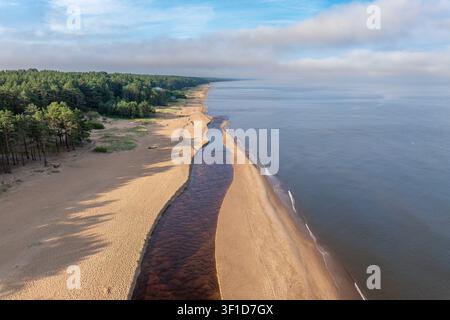 Estuaire de la rivière Peterupe se déversant dans la mer Baltique près de Saulkrasti, Lettonie, sous une lumière matinale chaude Banque D'Images