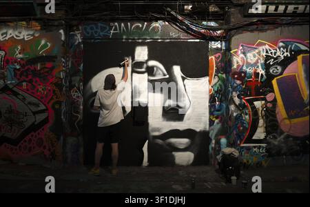 Artiste, artiste de graffiti, travaillant sur un portrait, graffiti légal et temporaire dans le Graffiti Tunnel, Leake Street Arches, Londres, Angleterre, Grande-Bretagne Banque D'Images