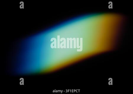 Spectre lumineux coloré abstrait créant un effet de prisme sur fond sombre Banque D'Images